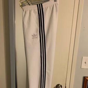 White and black adidas polyester track pants, size small.